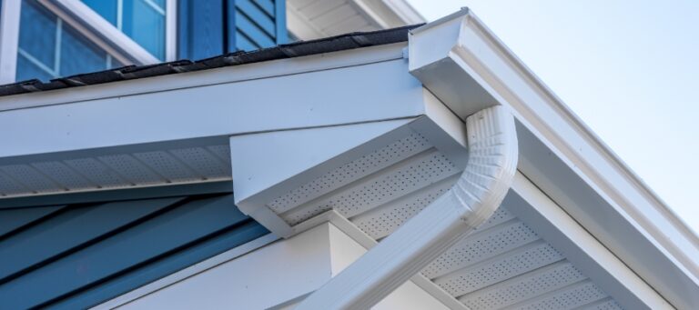 photo of white gutters on a blue-siding house
