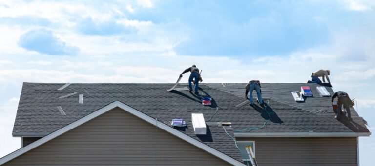 faraway photo of a group of roofers atop a house