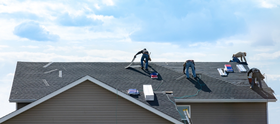 faraway photo of a group of roofers atop a house