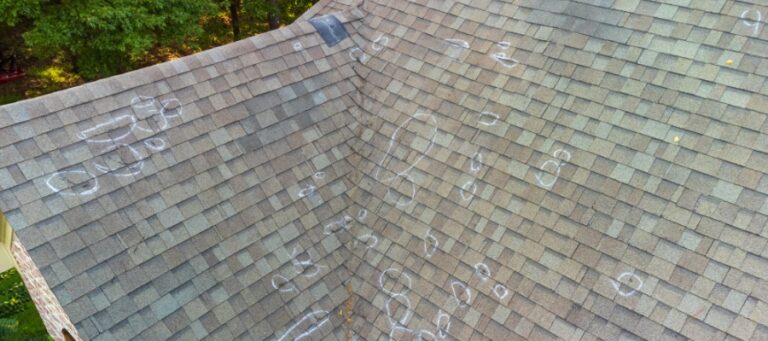 an asphalt shingle roof is marked up with chalk circle to note damage
