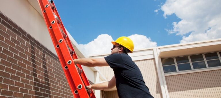 a man in a hard hat climbs a ladder to a roof