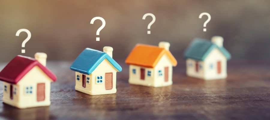 a row of tiny houses with question marks above them