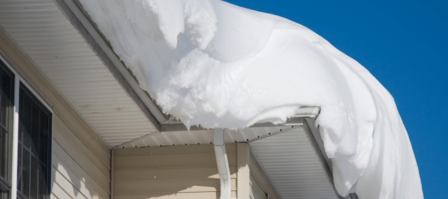 a large amount of snow sags off a home's roof